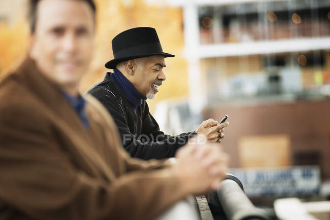 Men in coats leaning on a railing. — Stock Photo