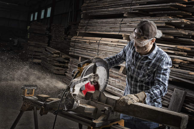 Людина використовує циркулярну пилку для різання деревини . — стокове фото