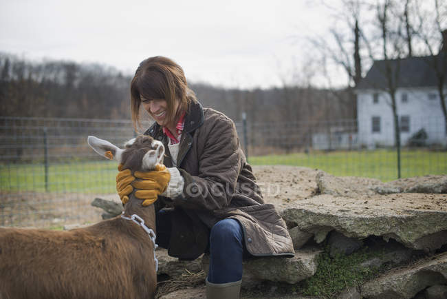 Mulher agricultora que cuida de cabras . — Fotografia de Stock