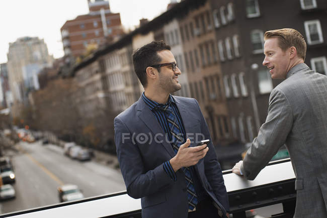 Men on an elevated walkway above road. — Stock Photo