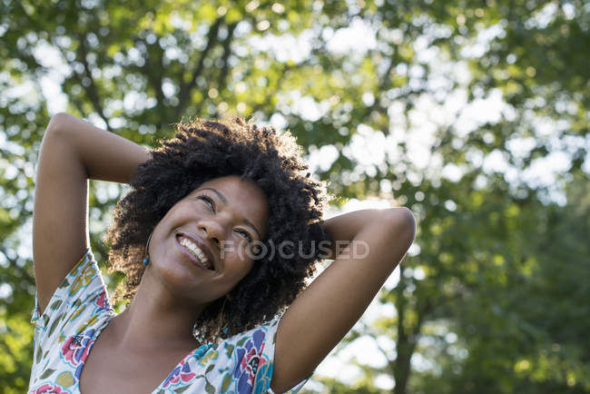 Jeune femme souriant et levant les yeux . — Photo de stock