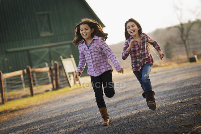 Crianças correndo ao longo de uma estrada — Fotografia de Stock