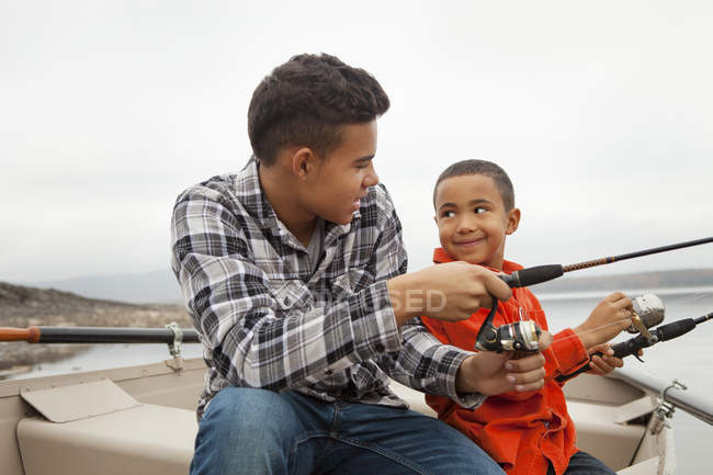 Zwei Jungen angeln von einem Boot aus. — Stockfoto