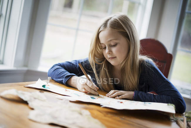 Menina desenho em um grande pedaço de papel . — Fotografia de Stock