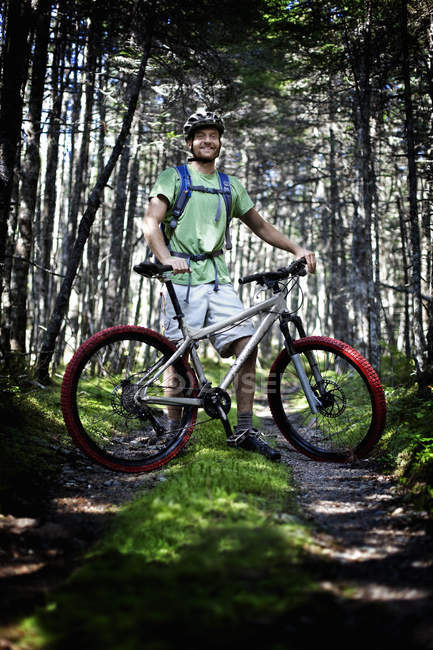 Homme avec vélo de montagne en forêt — Photo de stock