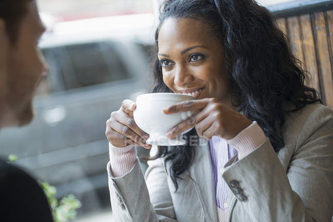 Woman in a coffee shop at a table — Stock Photo