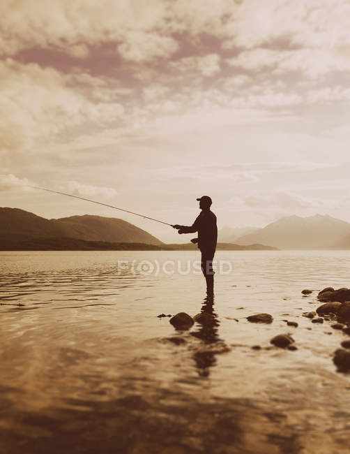 Silhouette of man fishing — Stock Photo