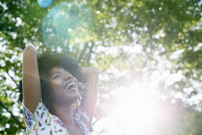 Mujer joven sonriendo y mirando hacia arriba . - foto de stock