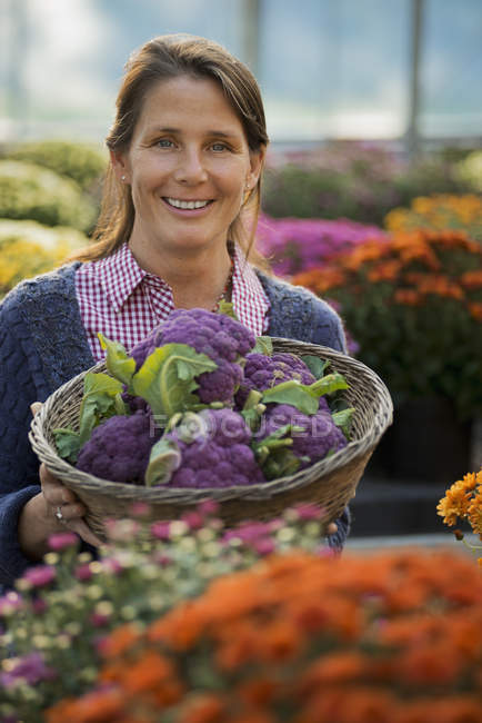 Frau hält lila Brokkoli in der Hand. — Stockfoto