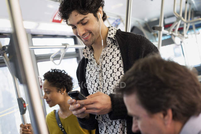 Homme vérifiant téléphone dans un bus de la ville — Photo de stock