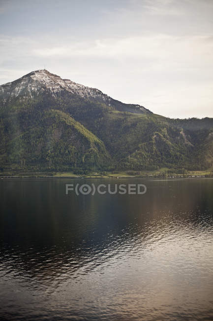 Cima di montagna che domina un lago — Foto stock