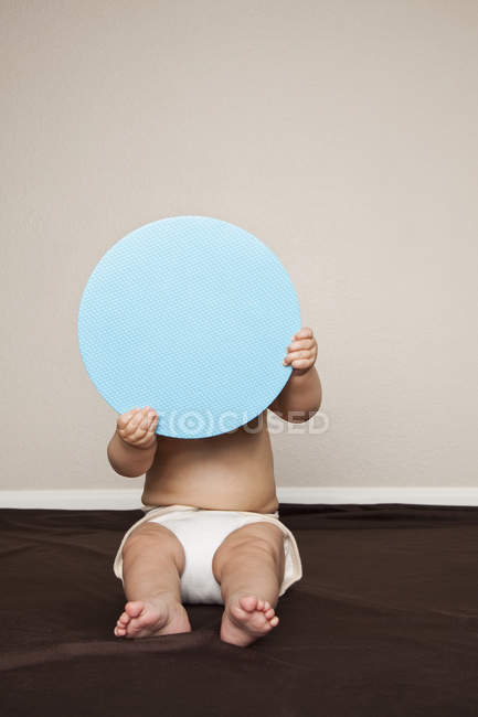 Bambino ragazzo nascosto dietro un disco . — Foto stock