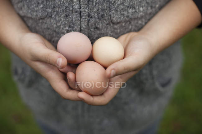 Жінка тримає зчеплення зі свіжими яйцями — стокове фото