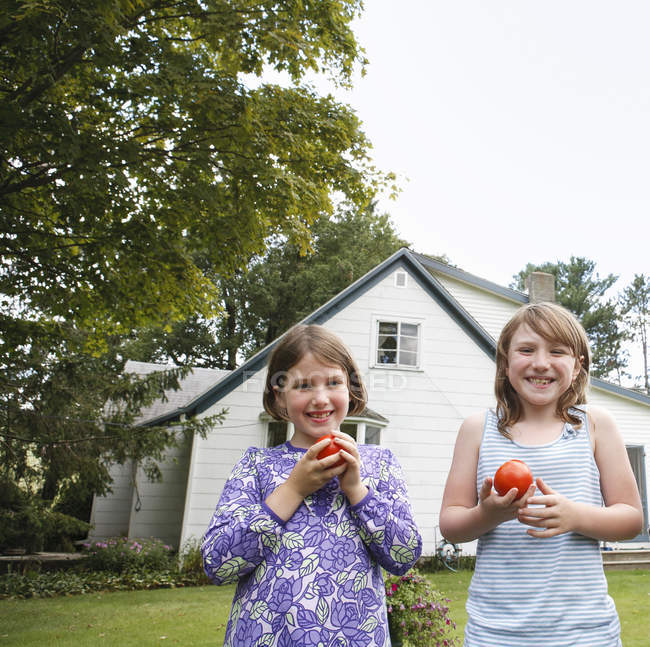 Mädchen essen frisch gepflückte Tomaten. — Stockfoto