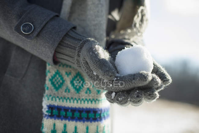 Mulher segurando uma pequena bola de neve — Fotografia de Stock