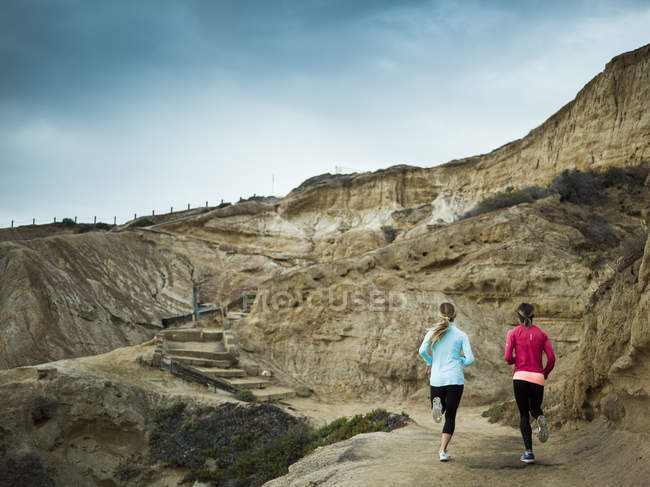 Mulheres correndo ao longo de uma trilha pedreira . — Fotografia de Stock
