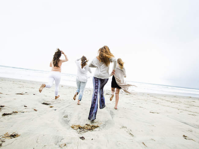 Donne che corrono su una spiaggia — Foto stock