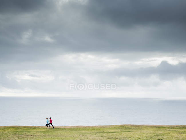 Women jogging along the coast. — Stock Photo