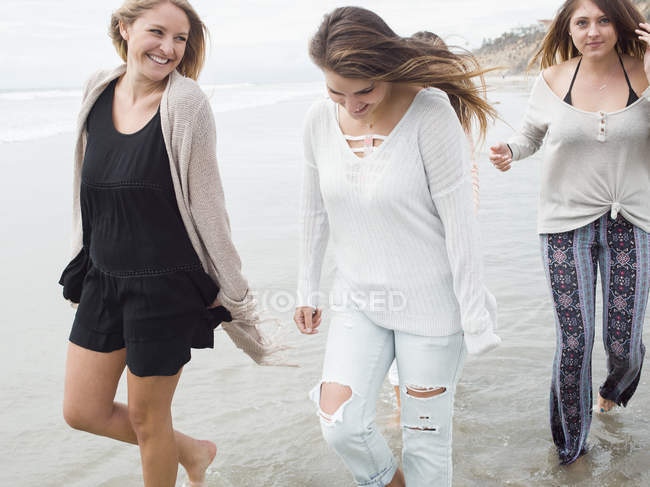 Mujeres caminando en una playa . - foto de stock