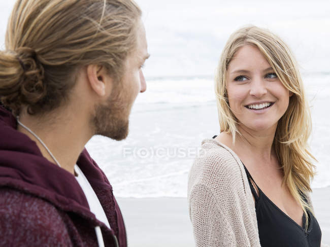 Casal caminhando em uma praia — Fotografia de Stock