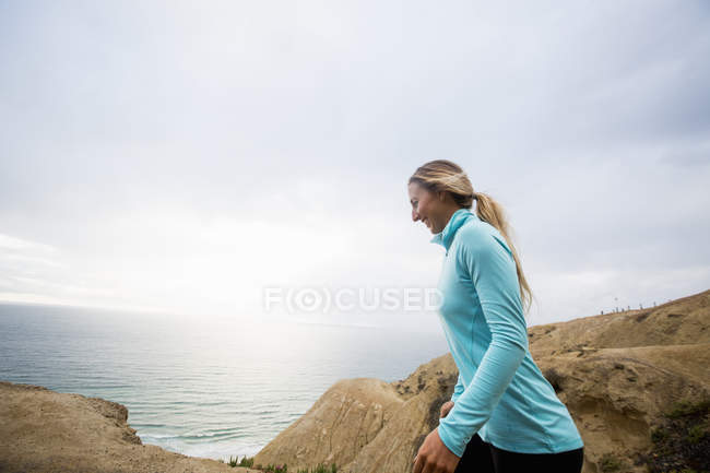 Frau joggt an der Küste entlang. — Stockfoto