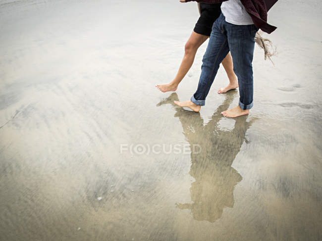 Coppia che cammina su una spiaggia — Foto stock