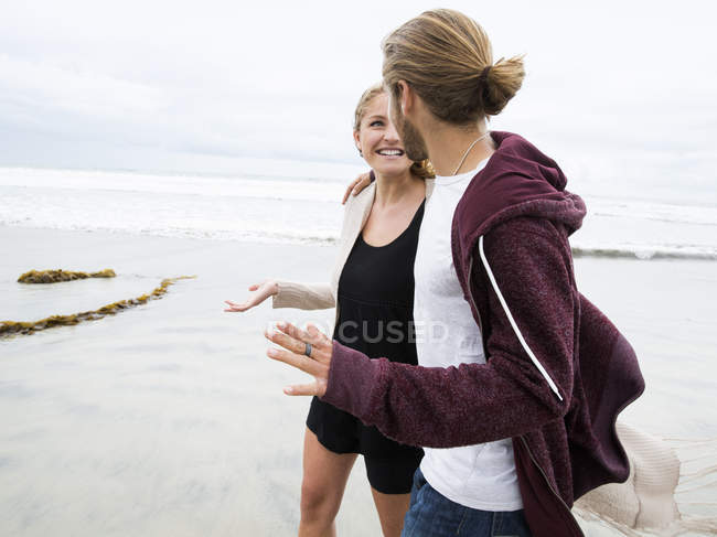 Coppia che cammina su una spiaggia — Foto stock