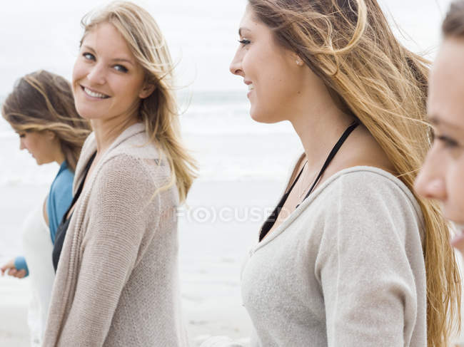 Mujeres caminando en una playa . - foto de stock