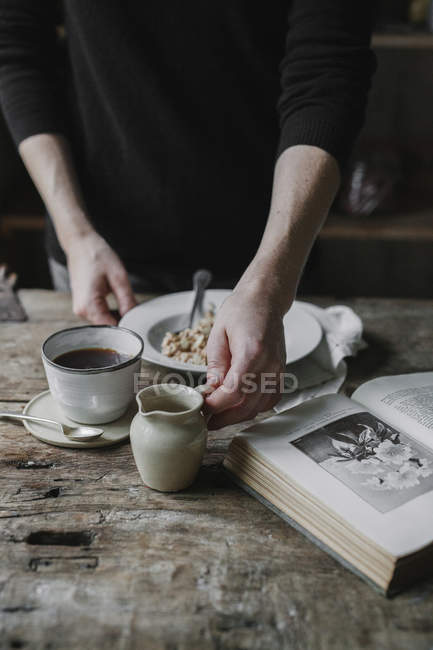Persona en una mesa con desayuno - foto de stock