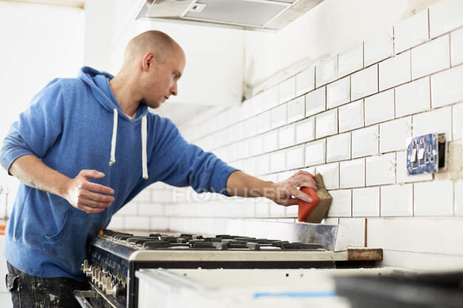 Homme travaillant dans une nouvelle cuisine — Photo de stock