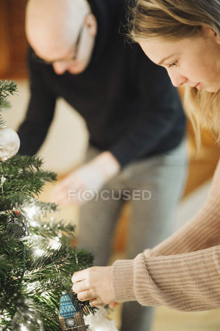 Отец и дочь украшают елку — стоковое фото