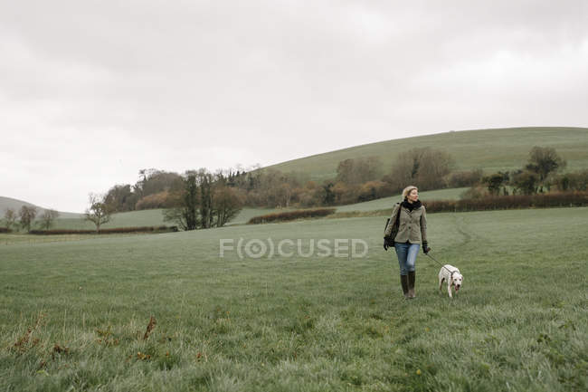 Femme marchant avec un chien — Photo de stock
