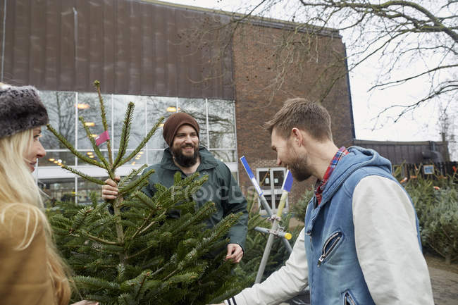 Personale e cliente guardando l'albero di Natale . — Foto stock
