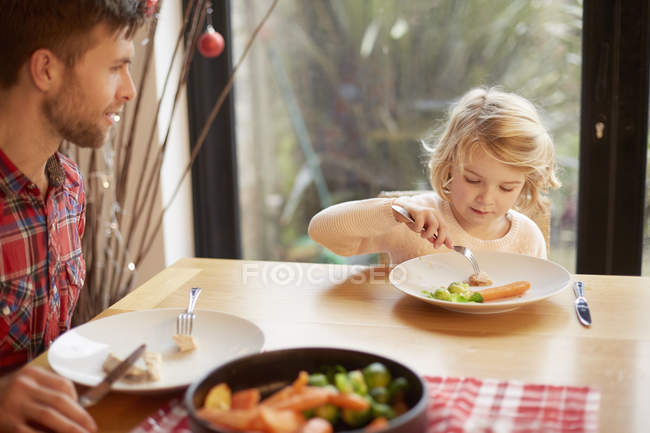 Niño y un hombre sentado en una mesa - foto de stock