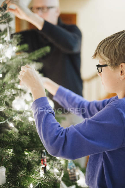 Hombre y niño decorando un árbol de Navidad - foto de stock