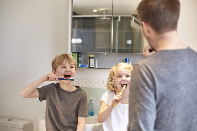 Niños limpiando sus dientes - foto de stock