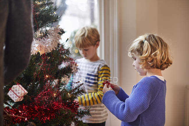 Crianças que decoram uma árvore de Natal — Fotografia de Stock