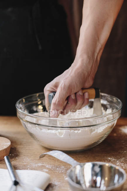 Person using a masher to soften butter — Stock Photo