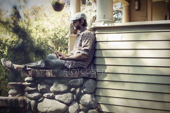 Uomo seduto in un angolo tranquillo di un portico — Foto stock
