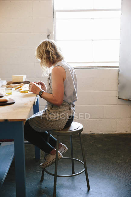 Mulher sentada em uma oficina . — Fotografia de Stock