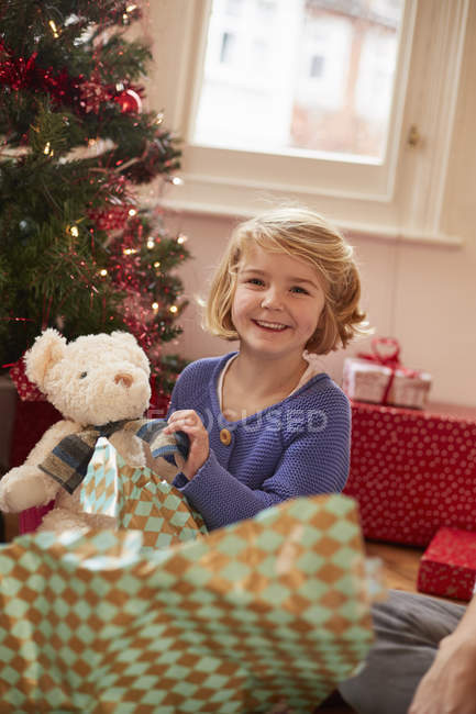 Menina desembrulhando um brinquedo macio — Fotografia de Stock