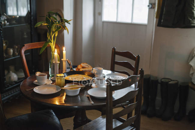 Mesa colocada para uma refeição com velas acesas — Fotografia de Stock
