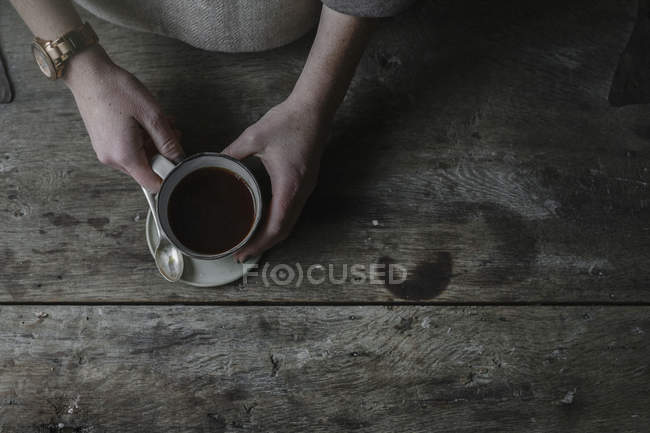 Femme mains levant tasse de soucoupe — Photo de stock