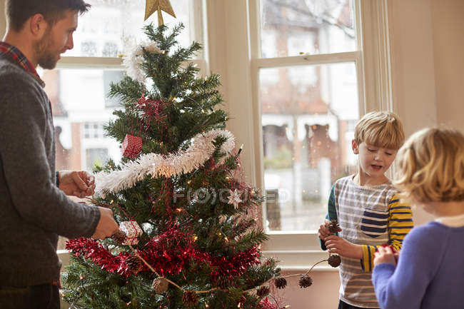 Familie schmückt Weihnachtsbaum zu Hause. — Stockfoto