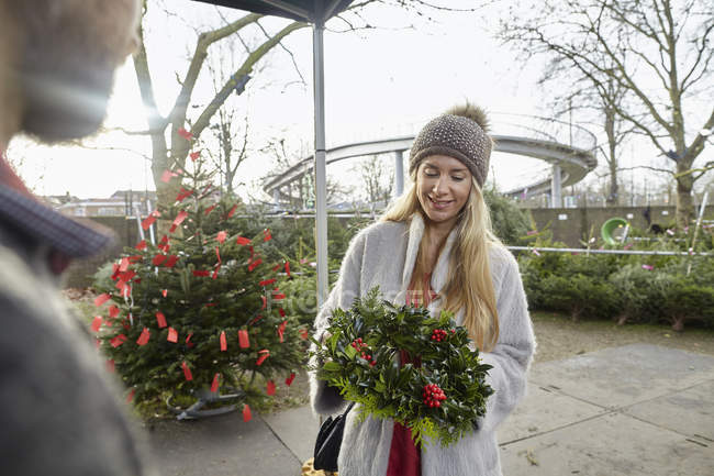 Donna hoilding una ghirlanda decorata di Natale — Foto stock
