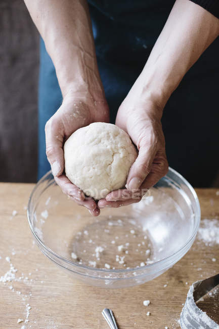 Man holding pastry dough in hands — Stock Photo