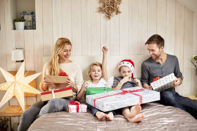 Família sentada na cama na manhã de Natal — Fotografia de Stock