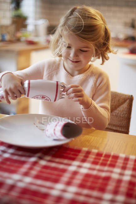 Ragazza che apre un cracker di Natale — Foto stock