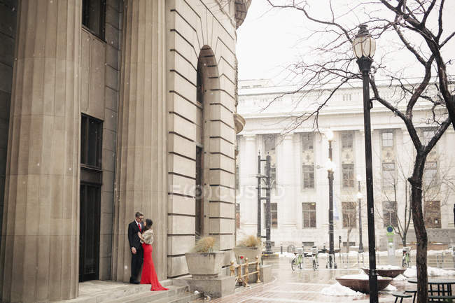 Couple à l'extérieur d'un grand immeuble dans une ville . — Photo de stock