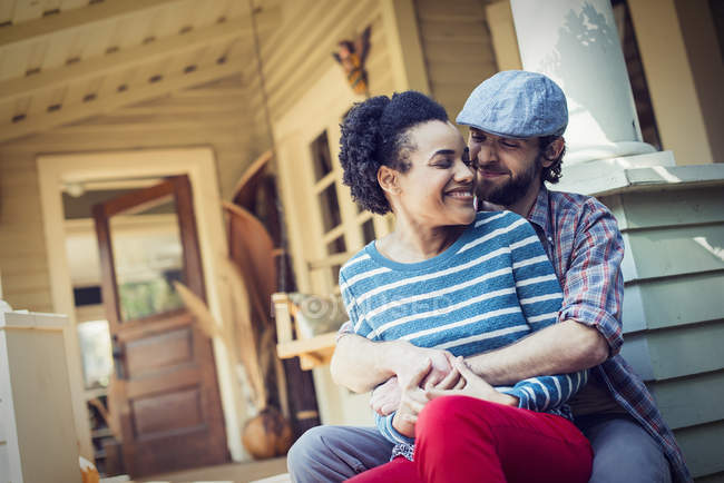 Couple seated on the porch steps — Stock Photo